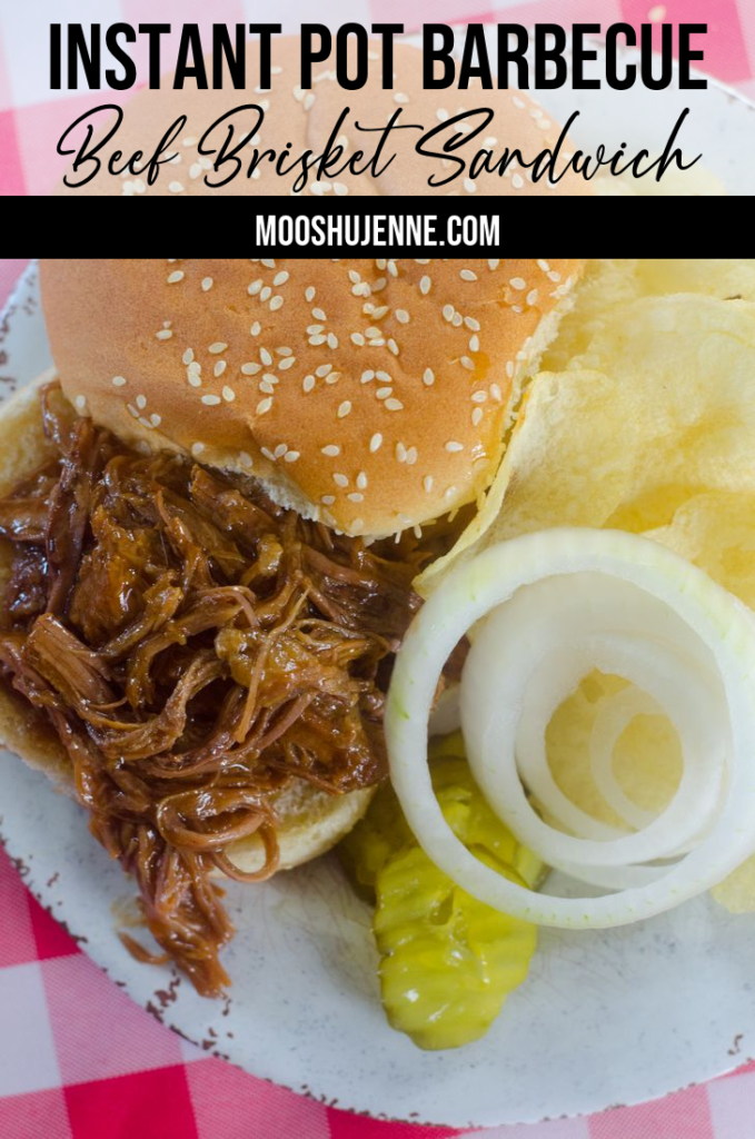 Instant Pot Barbecue Beef Brisket Sandwich on plate with onions, pickles, and chips.