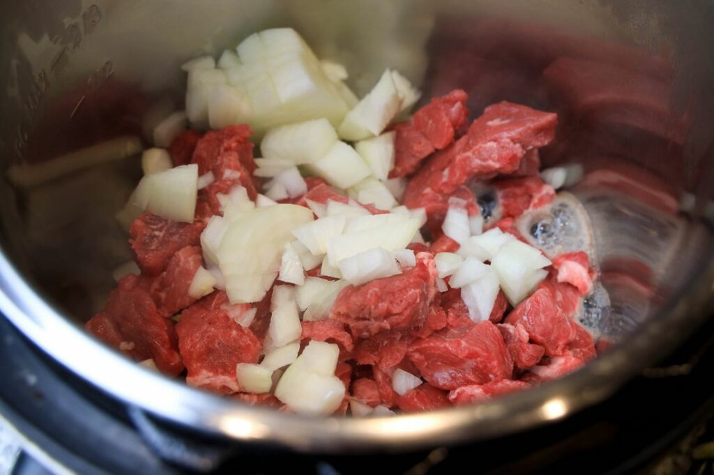 Beef and onion inside the instant pot.