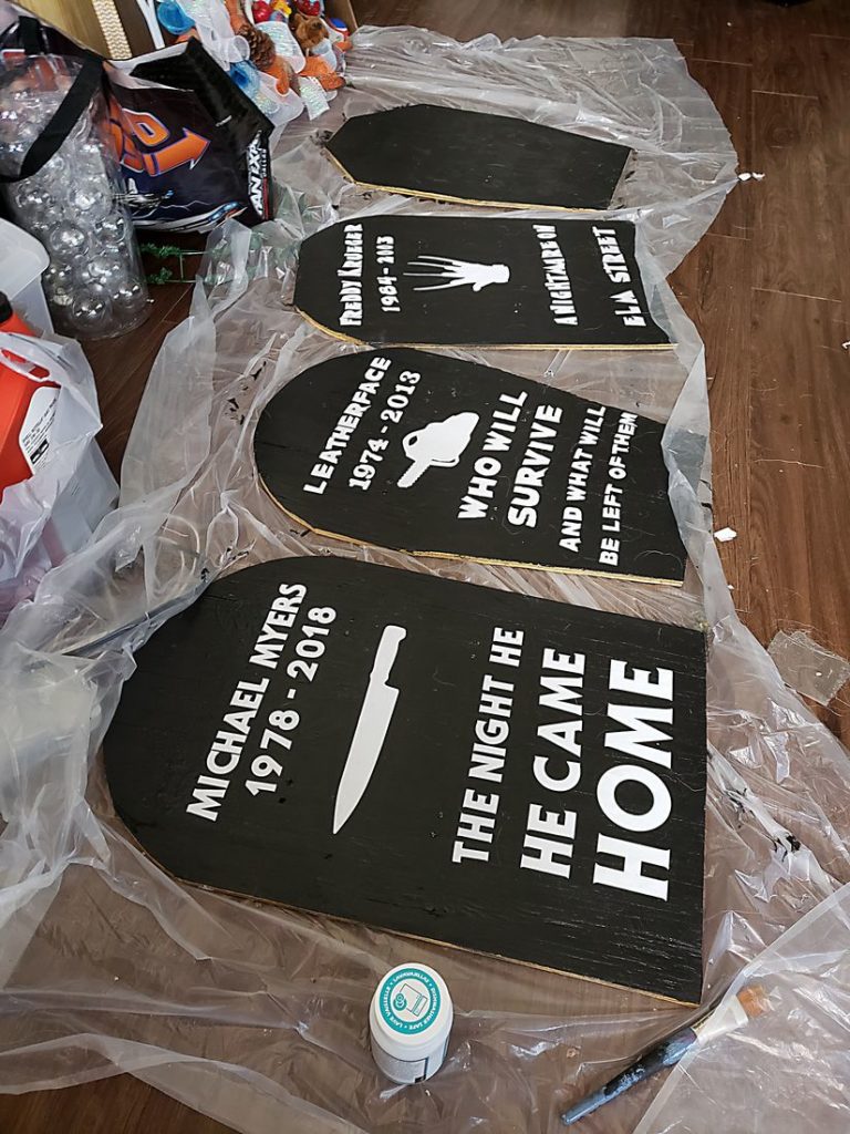 Gravestones laided out with lettering on plastic sheeting