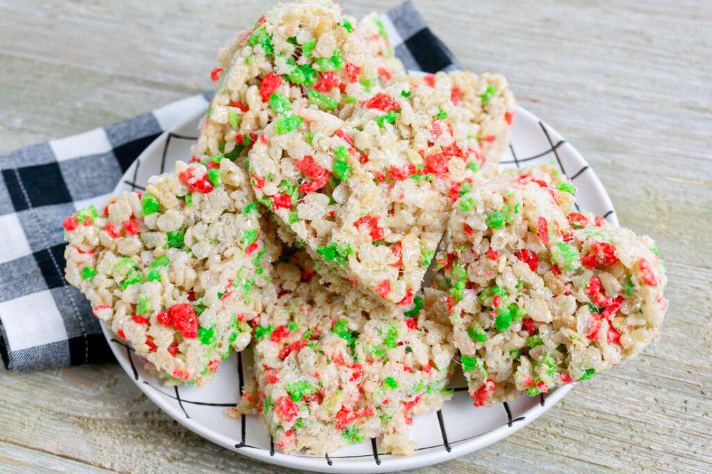 Rice Krispie Heart Holiday Treats made with Rice Kirispies Christmas cereal on a white and black plate.
