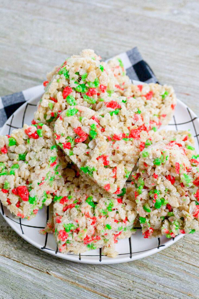 Rice Krispie Heart Holiday Treats made with Rice Kirispies Christmas cereal on a white and black plate.