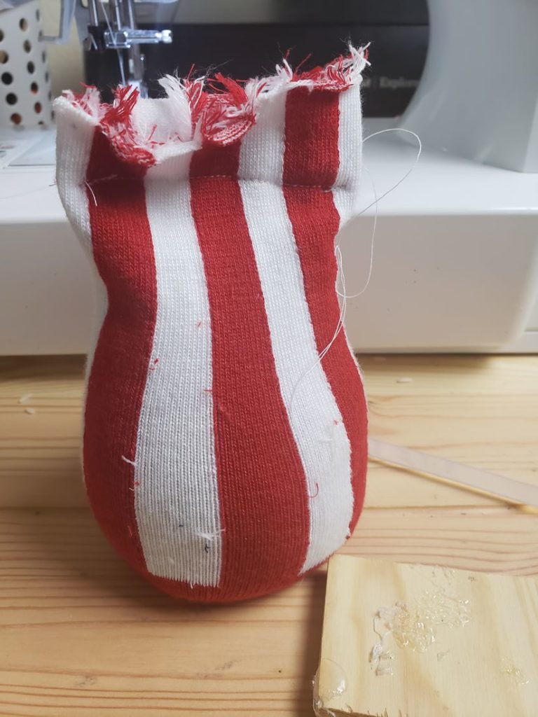 Red striped sock filled with rice and stitched