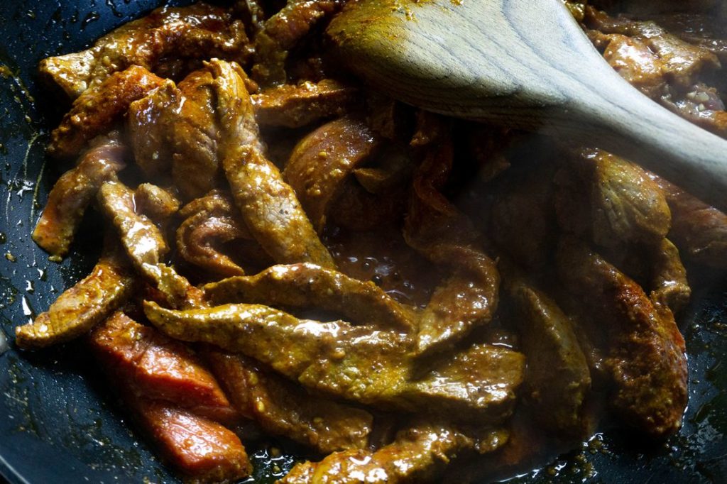 Beef in pan being sauteed