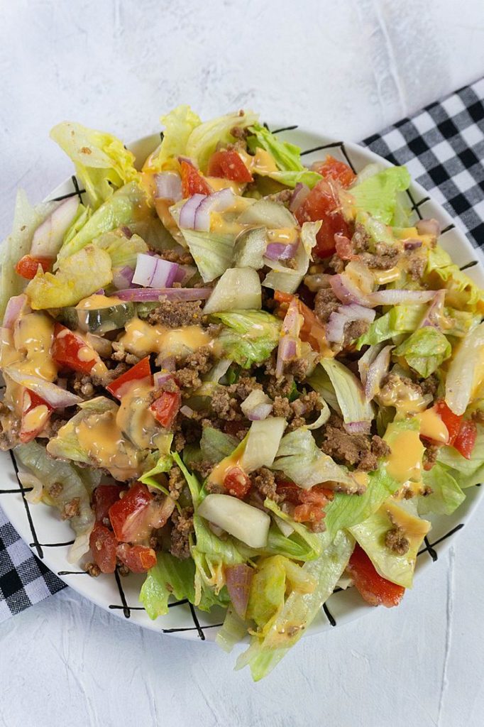 Big Mac Salad on white background with a plaid black napkin