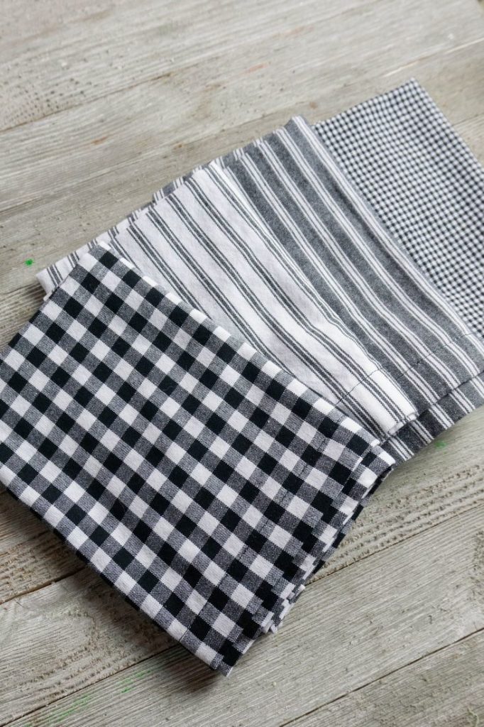 Cloth Napkins in gray, stripes, and plaid on gray wood background