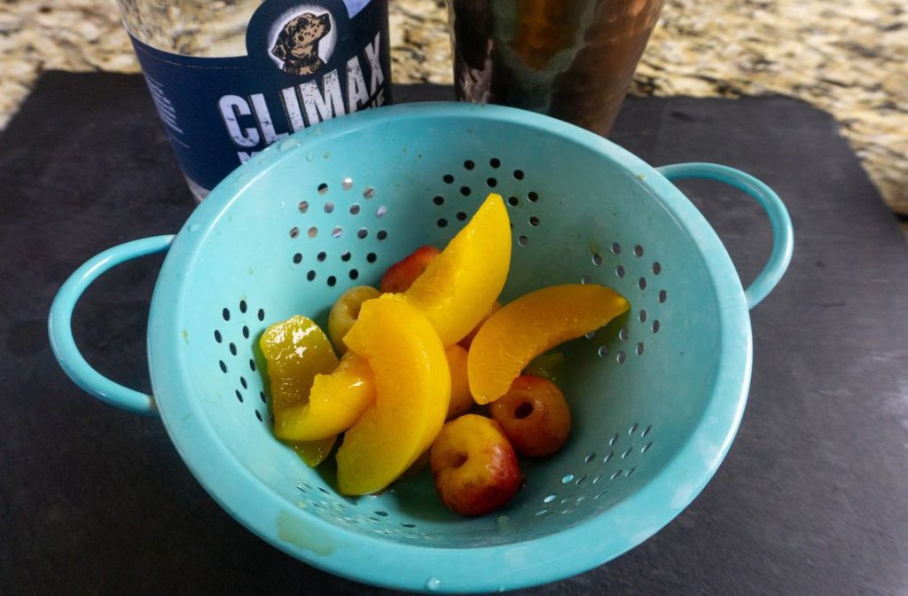 Peaches and Rainier cherries in a colander