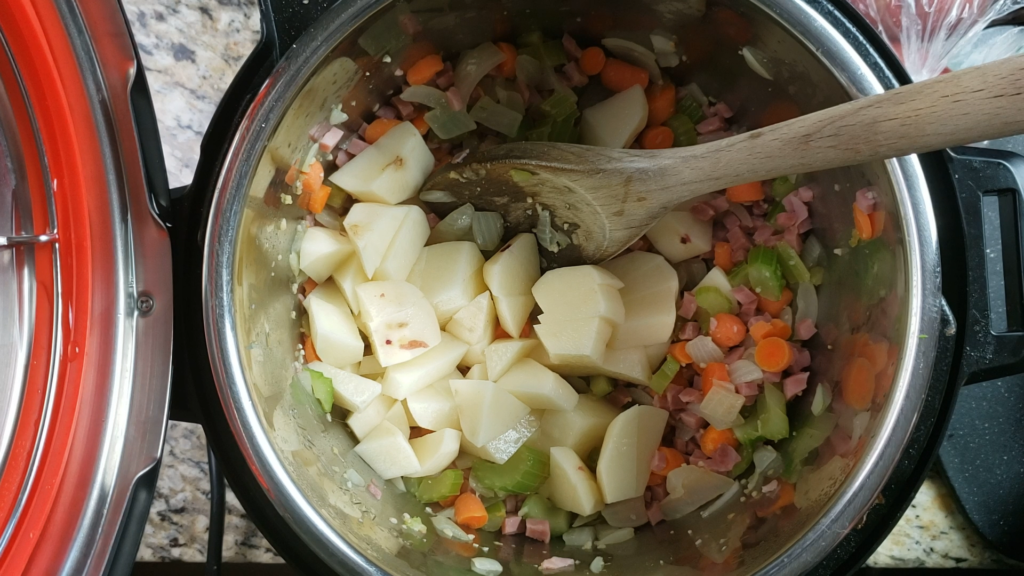 Potatoes, ham, and vegetables inside the instant pot. 