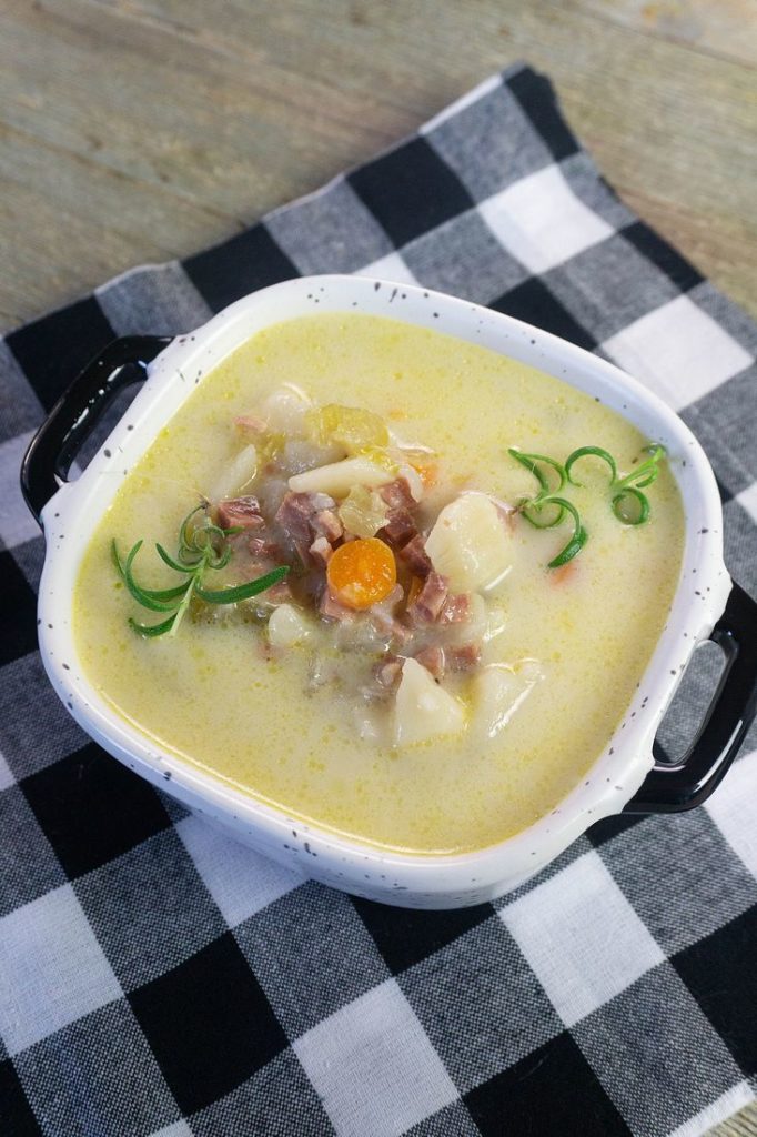 ham potato soup in a bowl on black plaid napkin