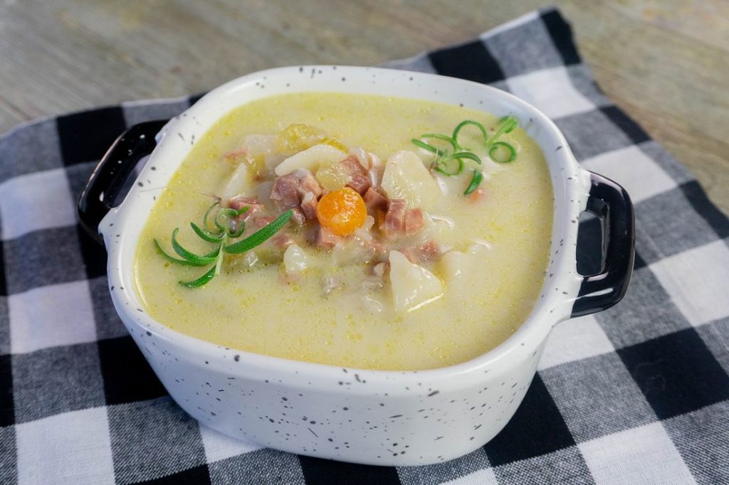 Instant Pot Ham Potato Soup on black plaid napkin and wood board.