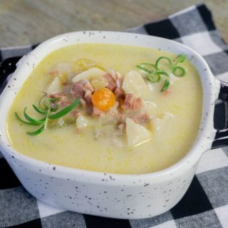 Instant Pot Ham Potato Soup on black plaid napkin and wood board.