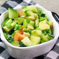 Avocado Cucumber Salad on grey backdrop with black and white plaid napkin