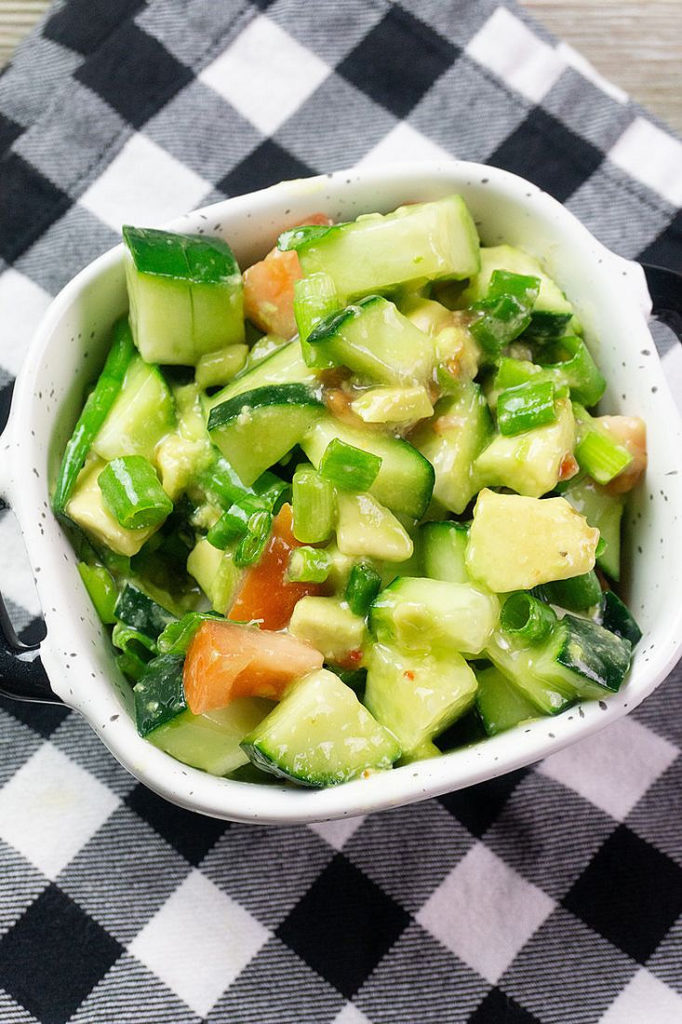 Avocado Cucumber Salad on grey backdrop with black and white plaid napkin