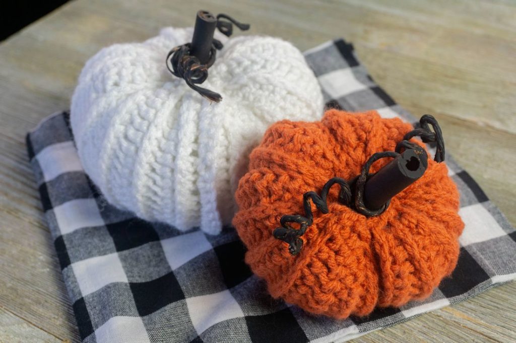 Farmhouse Crochet Pumpkins on plaid and gray wood.