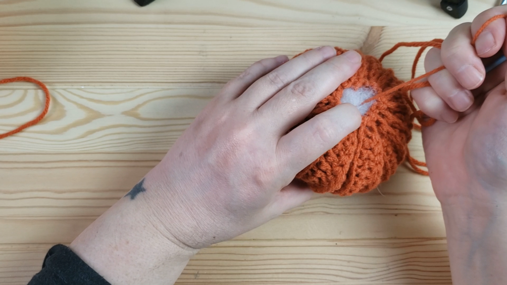 Pulling the yarn through to make a pumpkin shape