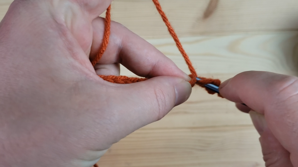 Chaining the orange pumpkin yarn 16 times.