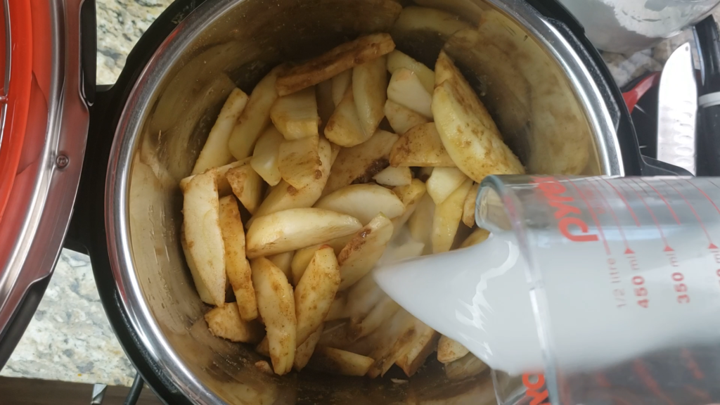 Pouring in cornstarch slurry onto apples inside the instant pot