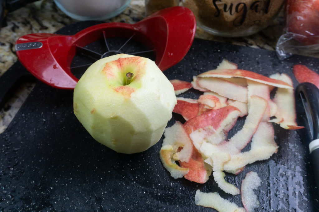 Peeled apples on black cutting board