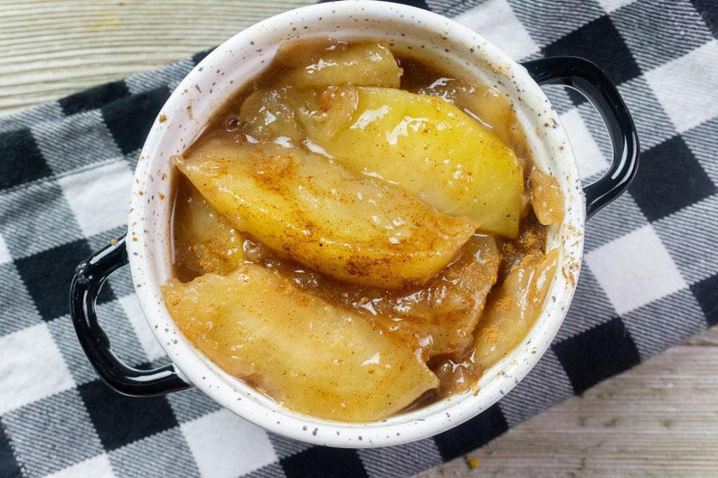 Instant Pot Cinnamon Apples on grey wood with black and white plaid napkin.