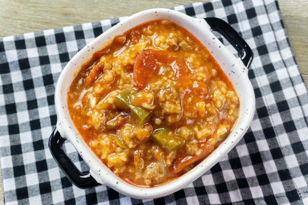 Instant Pot Czech Stuffed Pepper Soup in a black and white bowl on a black and white plaid napkin