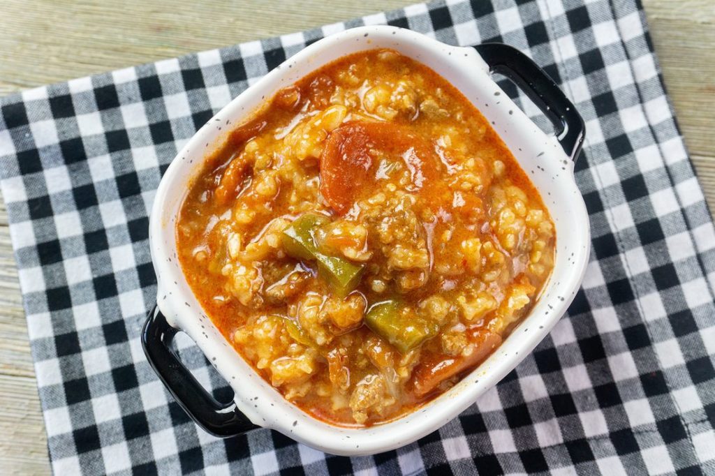 Instant Pot Czech Stuffed Pepper Soup in a black and white bowl on a black and white plaid napkin