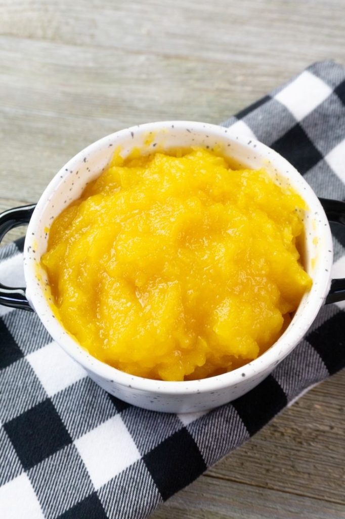 Instant Pot Pumpkin Puree in a white bowl with plaid napkin