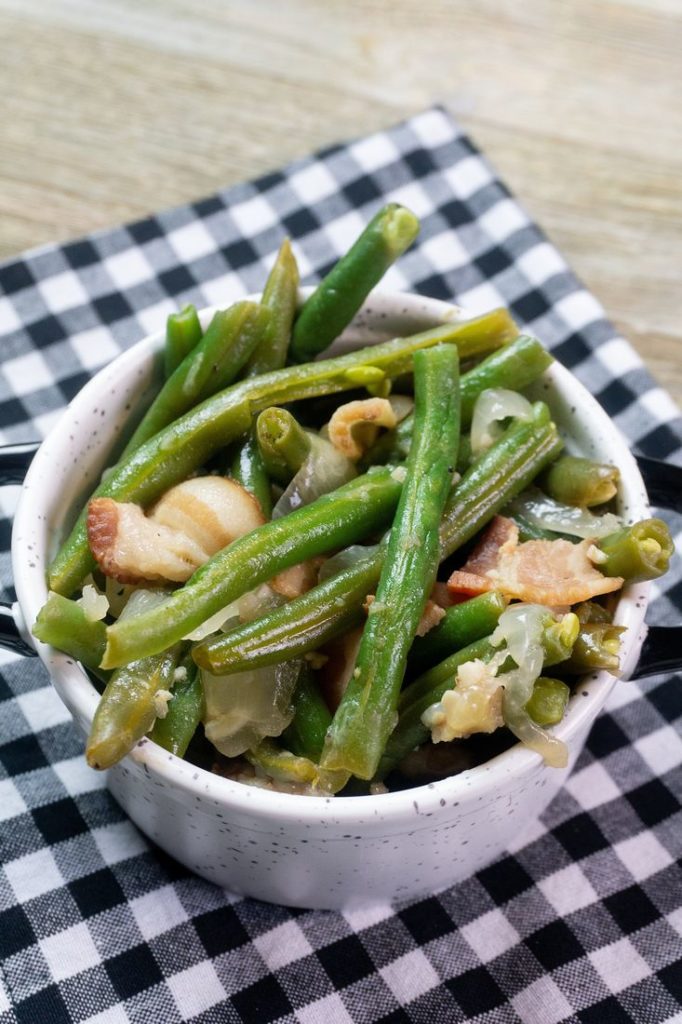 Instant Pot Bacon Green Beans inside a black and white bowl on a plaid napkin