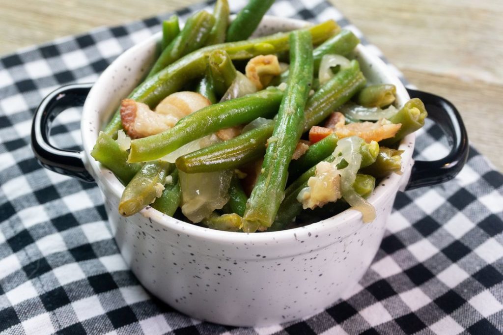 Instant Pot Bacon Green Beans inside a black and white bowl on a plaid napkin