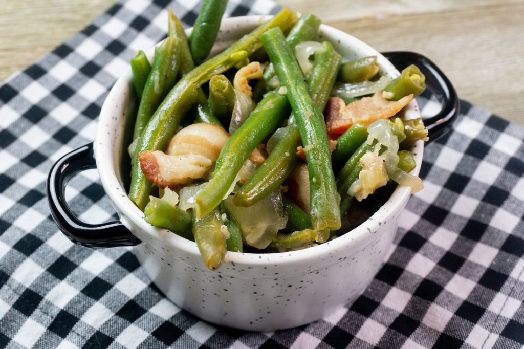 Instant Pot Bacon Green Beans inside a black and white bowl on a plaid napkin