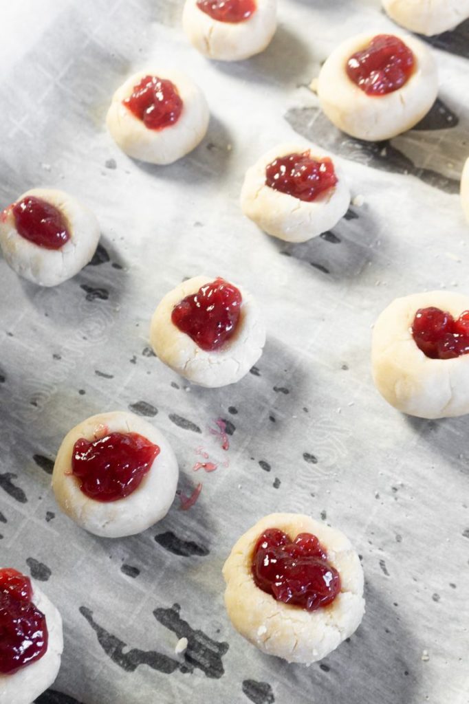 jam filled thumbprint cookies on baking sheet