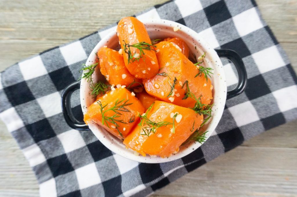 Instant Pot Garlic Dill Carrots on grey wood in a white bowl
