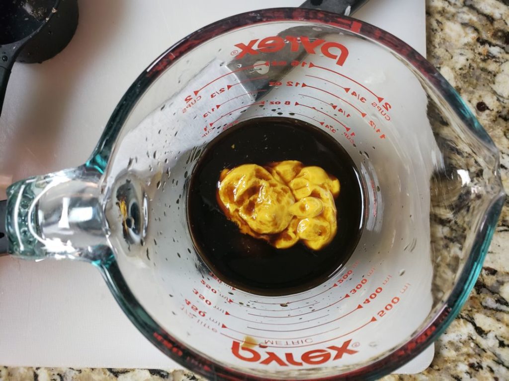 molasses with mustard in a pyrex measuring cup