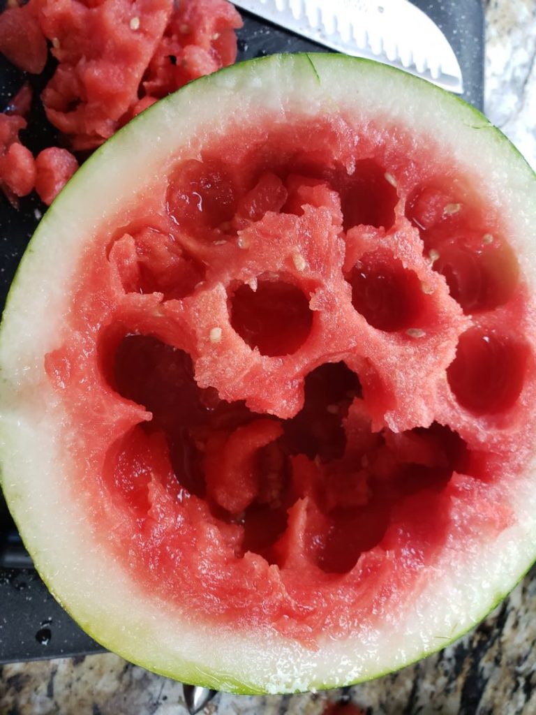 Watermelon cut in half with melon balls taken from the flesh