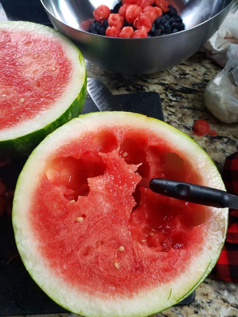Watermelon cut in half with melon balls taken from the flesh
