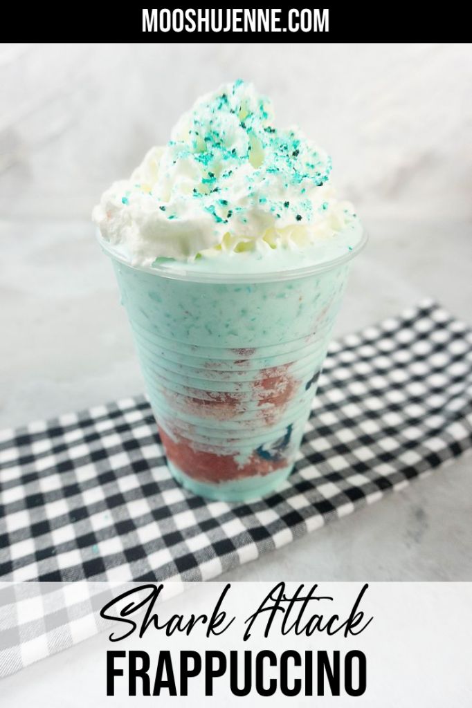 Shark Attack Frappuccino in a clear cup on a concrete background with plaid napkin