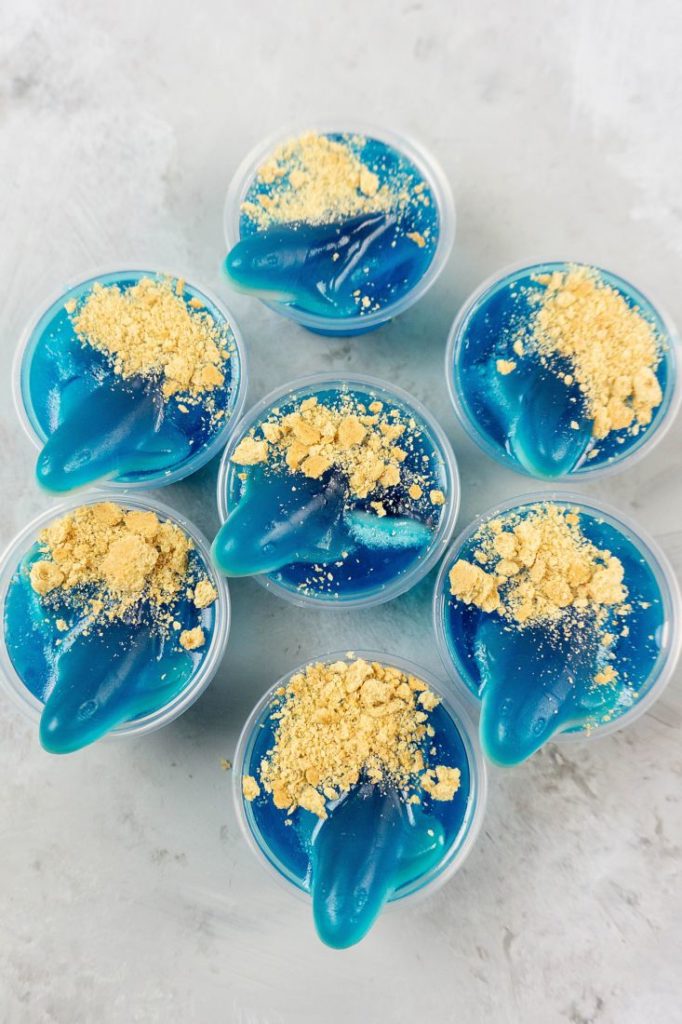 Shark Beach Jello Shots with gummy sharks, graham crackers as sand, and blue jello.