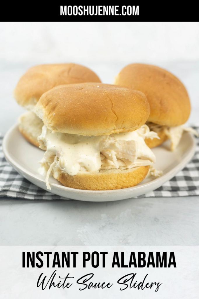 Instant Pot Alabama White Sauce Sliders on a white plate with gray plaid napkin and concrete back drop