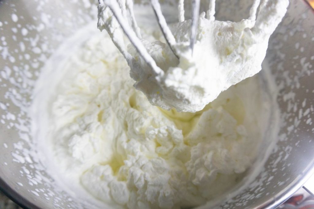 Heavy cream whipped into whipped cream in a stand mixer