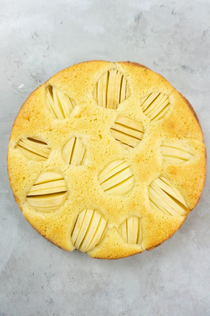 German Apple Coffee Cake with sliced apples on a concrete gray back drop