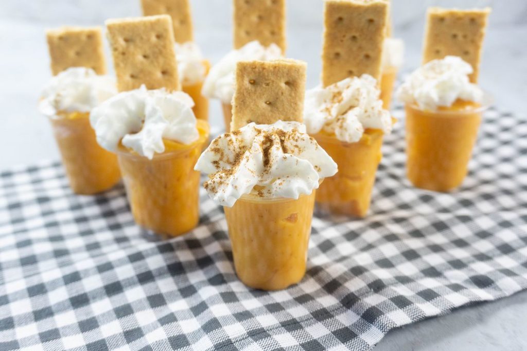 Pumpkin Pie Pudding Shots on a plaid napkin and concrete back drop