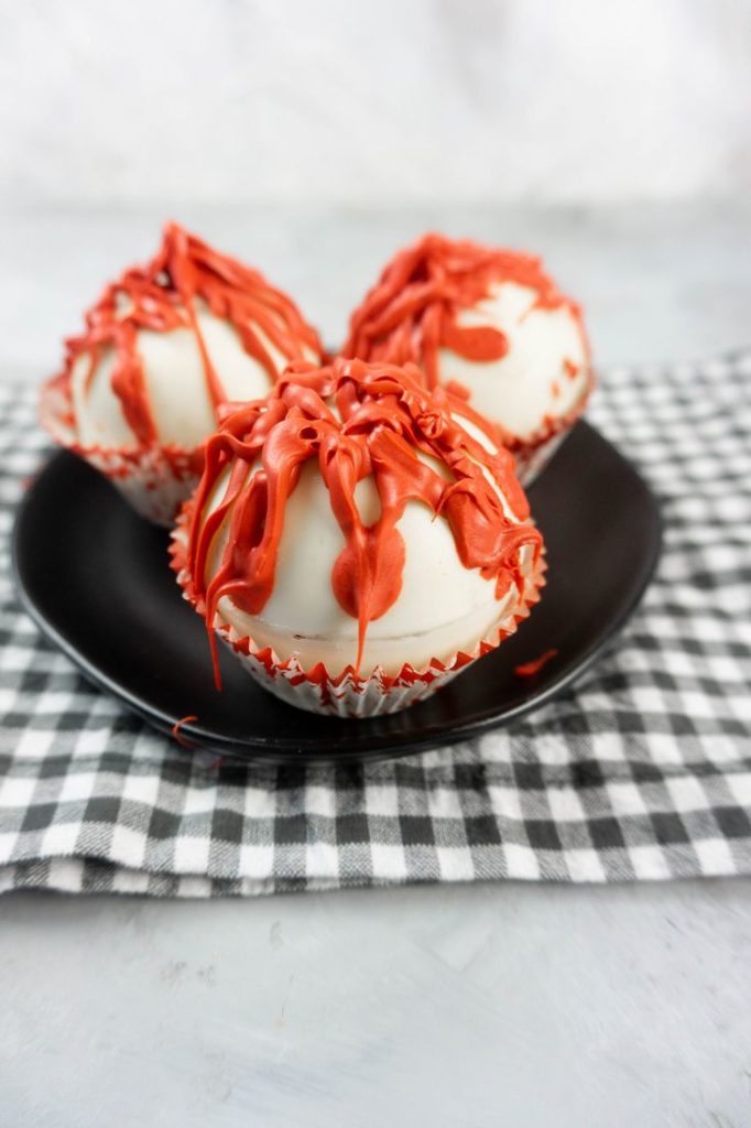 Bloody Michael Myers Hot Chocolate Bombs on black plate with plaid napkin and concrete back drop