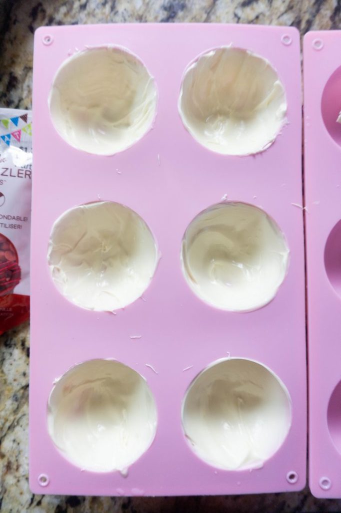 Candy melts in the mold to form hot chocolate bombs