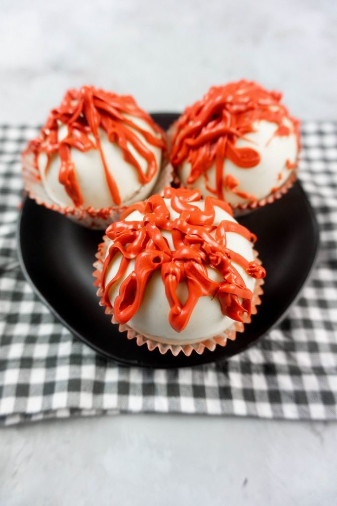 Bloody Michael Myers Hot Chocolate Bombs on black plate with plaid napkin and concrete back drop