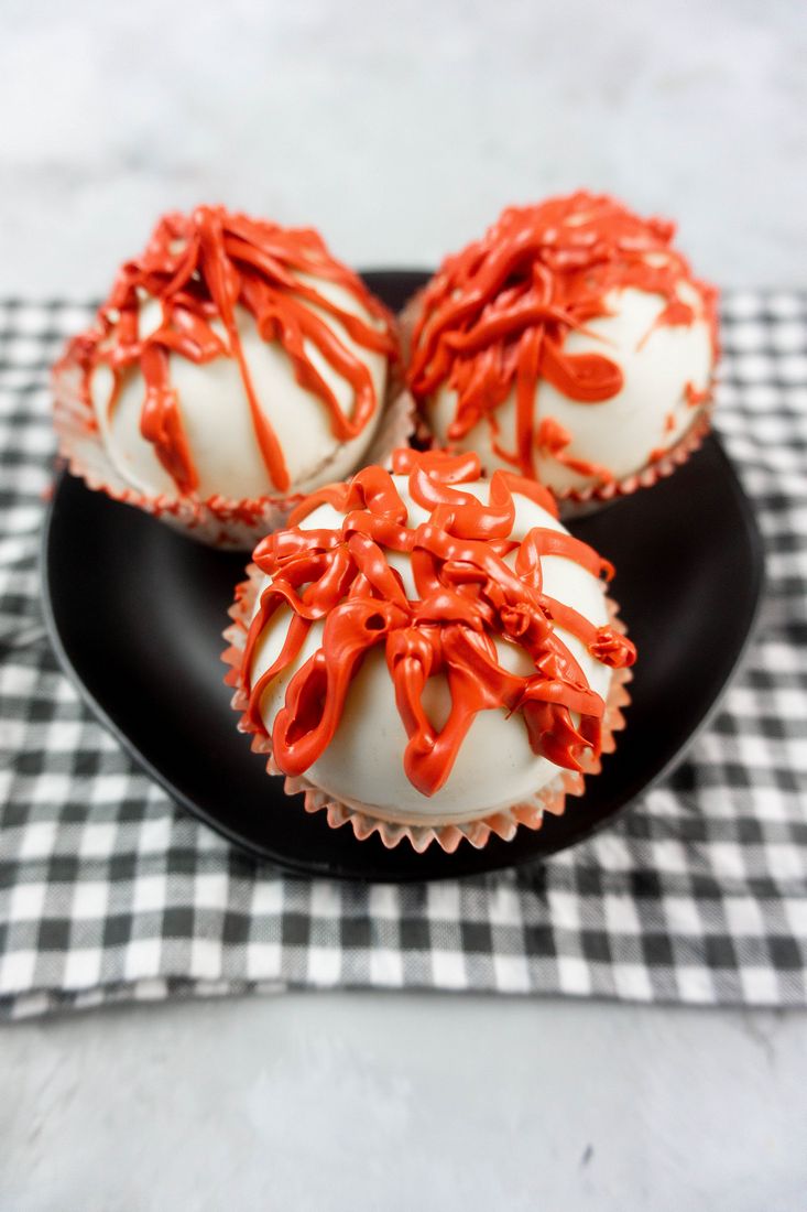 Bloody Michael Myers Hot Chocolate Bombs on black plate with plaid napkin and concrete back drop