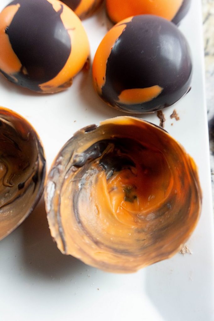 Orange and black halloween candy domes on a white plate