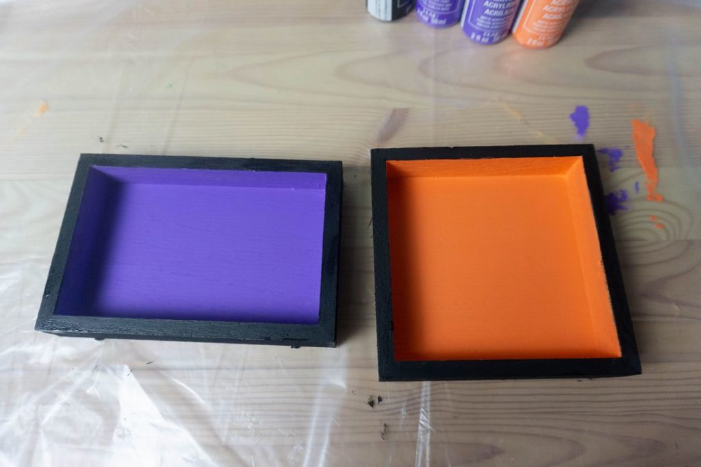Wood squares painted black rims with orange inside and purple inside