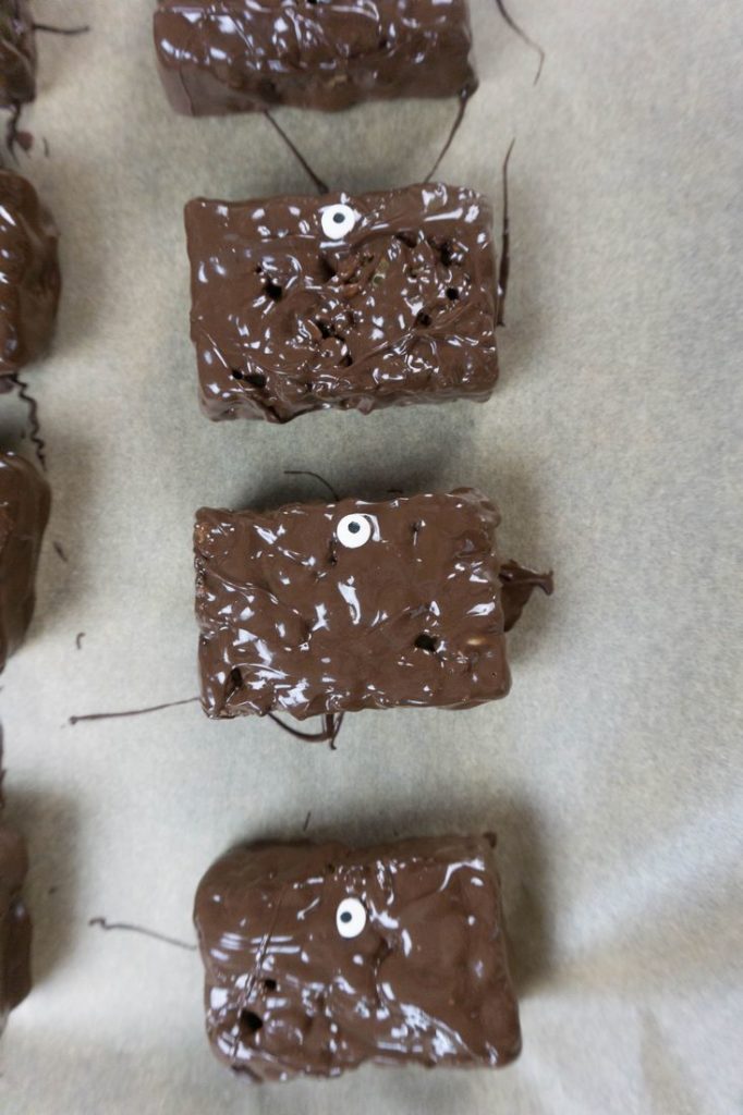 Rice krispies treats dipped in chocolate with candy eyes