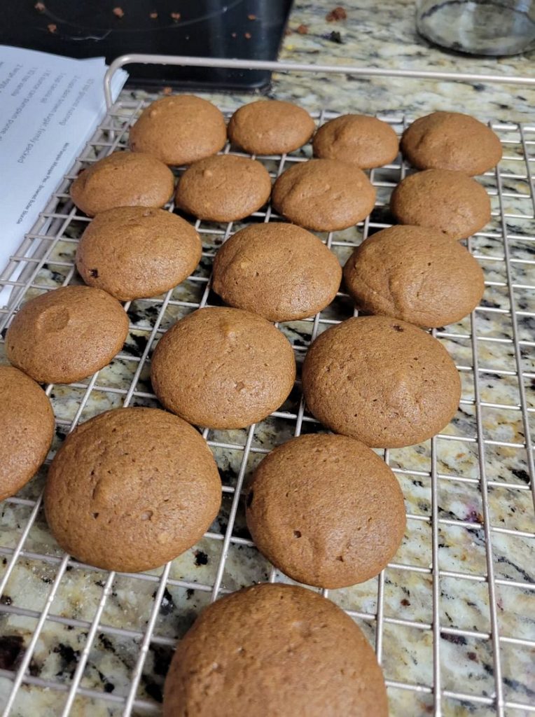 Cooked pumpkin whoopie pies cooling on a cooling rack