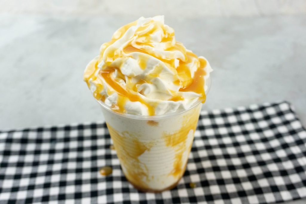 Butterbeer Frappuccino on a gray plaid napkin on a concrete backdrop