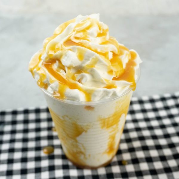 Butterbeer Frappuccino on a gray plaid napkin on a concrete backdrop