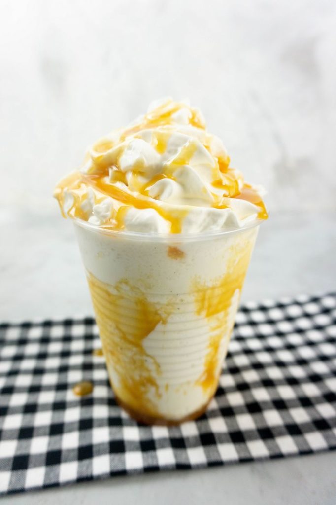 Butterbeer Frappuccino on a gray plaid napkin on a concrete backdrop